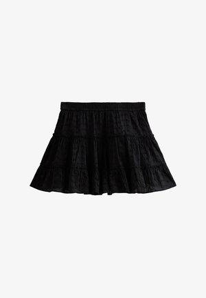 Black tiered skirt with an elastic waistband, made of textured fabric featuring subtle patterns. Flared shape and mid-thigh length.