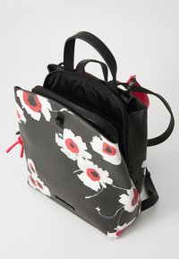 Zaino nero con motivo floreale che presenta fiori bianchi e rossi, pelle strutturata, molteplici scomparti con cerniera e spallacci regolabili.