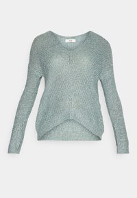 Ljusblå långärmad tröja med texturerad stickning, rundad halsringning och en böjd nederkant. Lappen läser "JDY."