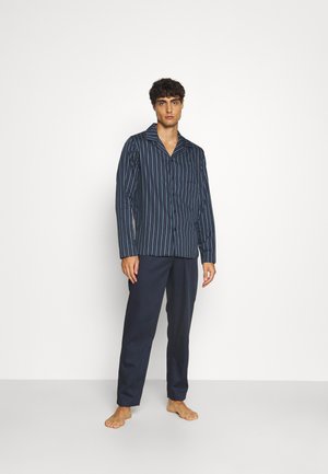 Marineblå stribet pyjamas sæt med lange ærmer og knaplukning fortil, der har mørke bukser og en afslappet pasform. Glat stofstruktur.