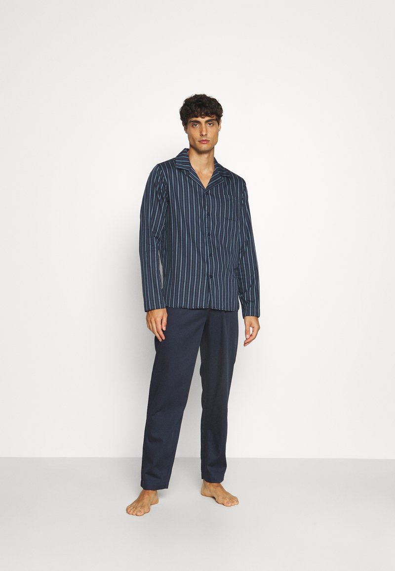 Set di pigiama a righe blu navy con maniche lunghe e chiusura con bottoni, caratterizzato da pantaloni scuri e una vestibilità comoda. Tessuto dalla trama liscia.