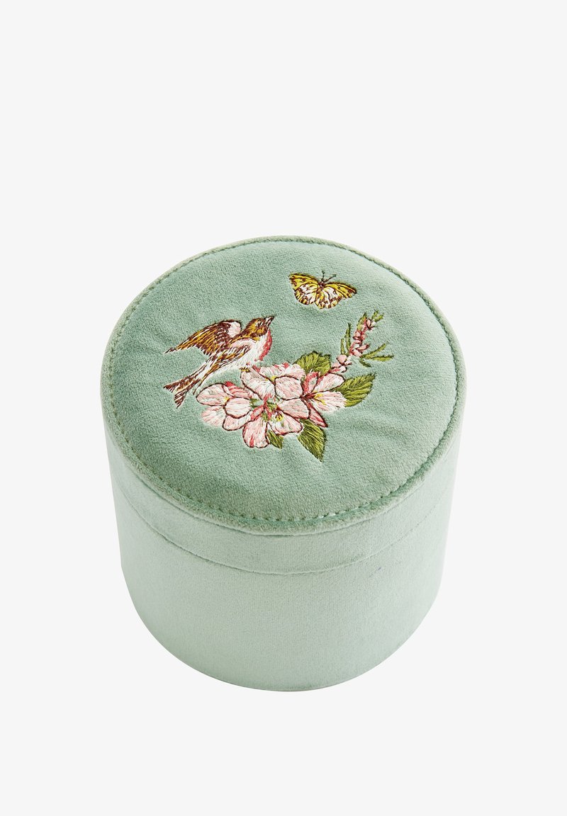Round, soft green velvet storage box with floral and bird embroidery on the lid. Features a smooth texture and subtle stitching detail.