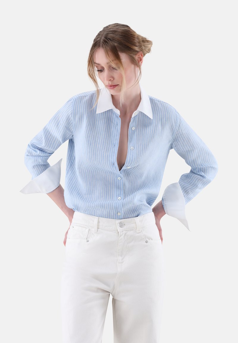 Light blue striped shirt with white collar and cuffs, button-down front, relaxed fit, paired with white high-waisted trousers.