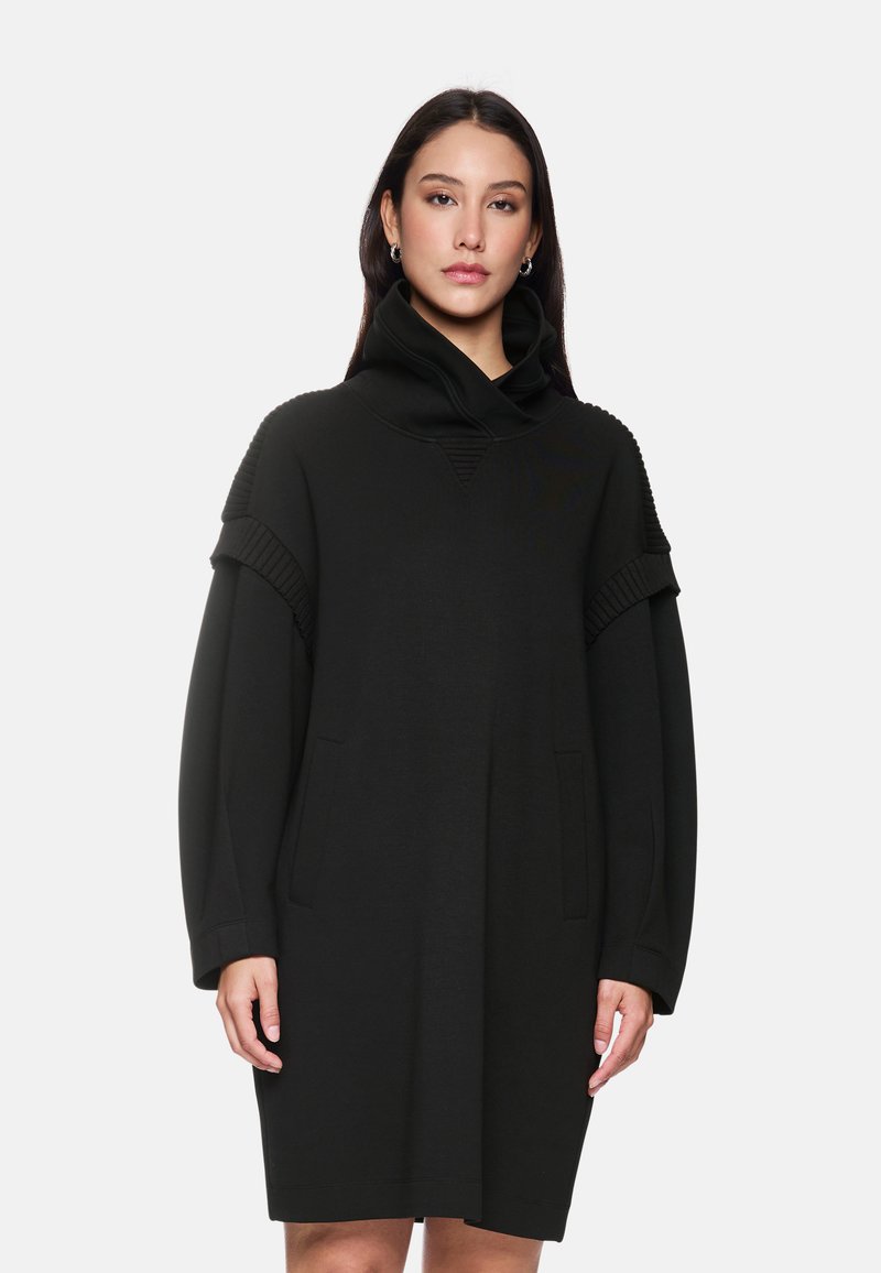 Schwarzes, übergroßes Kleid aus weichem Stoff, mit hohem Kragen, gerippten Ärmelakzenten und zwei vorderen Taschen.
