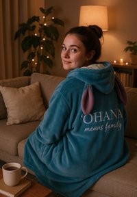 Felpa in felpa turchese con orecchie viola e la scritta "‘OHANA significa famiglia" ricamata in bianco. Materiale morbido, maniche lunghe e vestibilità comoda.