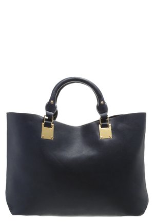 Sort læderhåndtaske med afrundede håndtag og guldrektangulært metalbeslag, der har et glat, struktureret design.