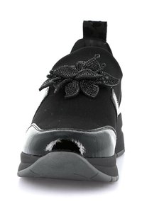 Sneaker nero con tomaia testurizzata, caratterizzata da un accento floreale e dettagli in vernice lucida. Suola piatta per comfort e stabilità.