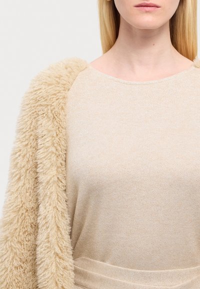 Beiger Strickpullover mit einem weichen, flauschigen beigen Pelzschalkragen, der über einen runden Ausschnitt verfügt und einen leichten Glanz im gesamten Stoff aufweist.