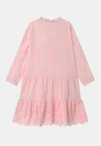 Abito rosa a maniche lunghe con scollatura arricciata e orlo a strati. Presenta dettagli in pizzo nella parte inferiore e una texture di cotone morbido.