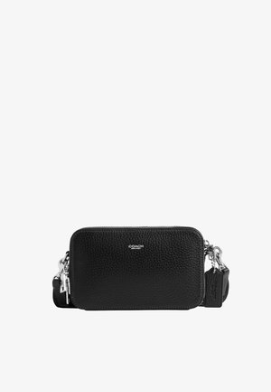 Pochette Coach en cuir noir texturé avec fermeture éclair argentée, sangle amovible et étiquette en cuir embossée sur fond blanc.