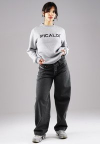 Gray sweatshirt with "PICALDI" logo, paired with dark gray wide-leg jeans and gray sneakers. Soft fabric and relaxed fit.