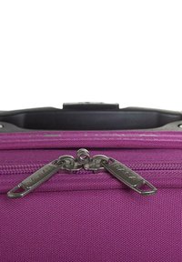 Maleta de tela morada con dobles cremalleras metálicas, con una superficie texturizada y un asa superior de plástico. Diseño simple, estructura ligera.