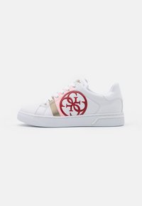 Sneaker bianco in materiale sintetico liscio, logo rosso circolare, dettagli rosa e oro, punta arrotondata e suola piatta in gomma.