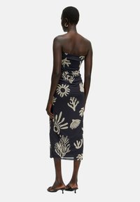 Trägerloses, figurbetontes Midi-Kleid aus navy Stoff mit abstrakten cremefarbenen Mustern, die Korallen und Muscheln ähneln, mit einem gerafften Design.