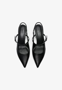 Čierne kožené slingback vysoké podpätky s špicatými prstami, tenkými remienkami na členkoch a hladkým, textúrovaným povrchom. Ozdoby obsahujú detail pracky.