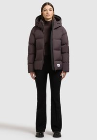 Chaqueta acolchada de color púrpura oscuro con un diseño ajustado, que cuenta con capucha, cierre de cremallera y un acento negro. Textura suave y patrón acolchado.