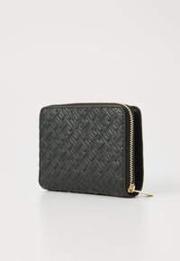 Portefeuille noir en cuir texturé, présentant un motif géométrique, une fermeture éclair dorée, et une forme rectangulaire au design compact.