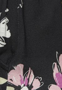 Black fabric featuring floral patterns in pink and cream, with textured surface and smooth finish. Details include outlined flowers and leaves.