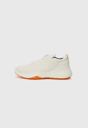 Light beige sneaker with a textured upper, orange sole, and reflective accents. Features elastic laces and a cushioned midsole for comfort.
