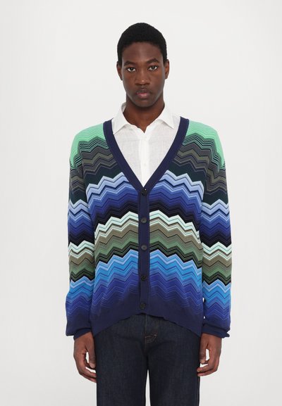 Cardigan lavorato a maglia con motivo a zigzag in tonalità di blu, verde e blu navy, con scollatura a V, maniche lunghe e chiusura frontale con bottoni.