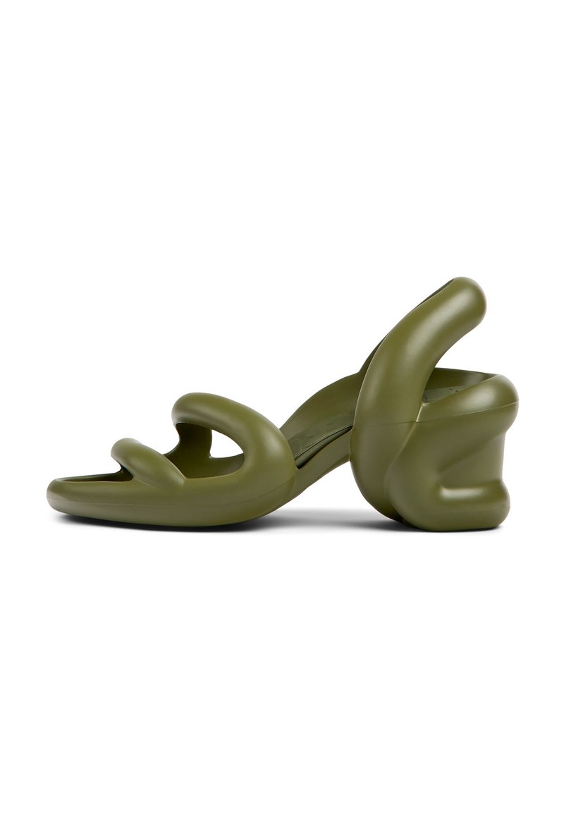 Olive green high-heeled sandals with sculptural, twisted straps and a chunky, contoured heel. Made of a smooth, flexible material.