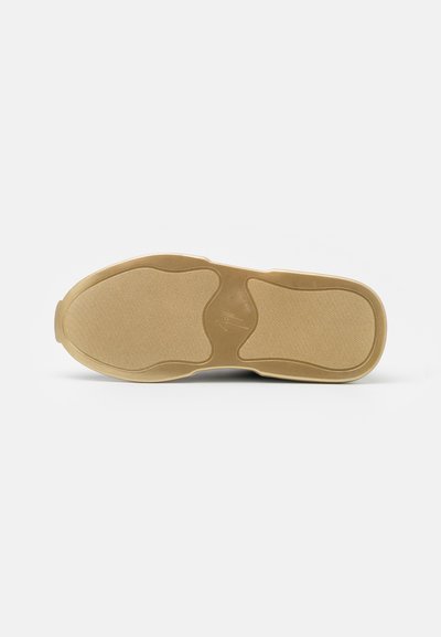 Sola de sapato em borracha com um acabamento texturizado na cor mel. Apresenta ranhuras distintas e detalhes de logotipo para maior aderência e estilo.