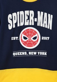 Marineblaue Sweatshirt mit gelben Akzenten. Enthält den Schriftzug "SPIDER-MAN" in Weiß, ein rotes Spider-Man-Logo und den Text "QUEENS, NEW YORK" in Weiß.