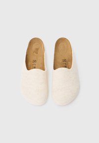 Mules blancos de fieltro con un diseño abierto en la parte trasera, punta redondeada y una plantilla beige natural. La superficie tiene una textura suave, mostrando un diseño minimalista.