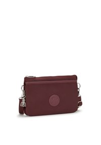 Pequeña bolsa cruzada rectangular burdeos con bolsillo frontal con cremallera, correa ajustable y logotipo circular en relieve en la parte delantera.
