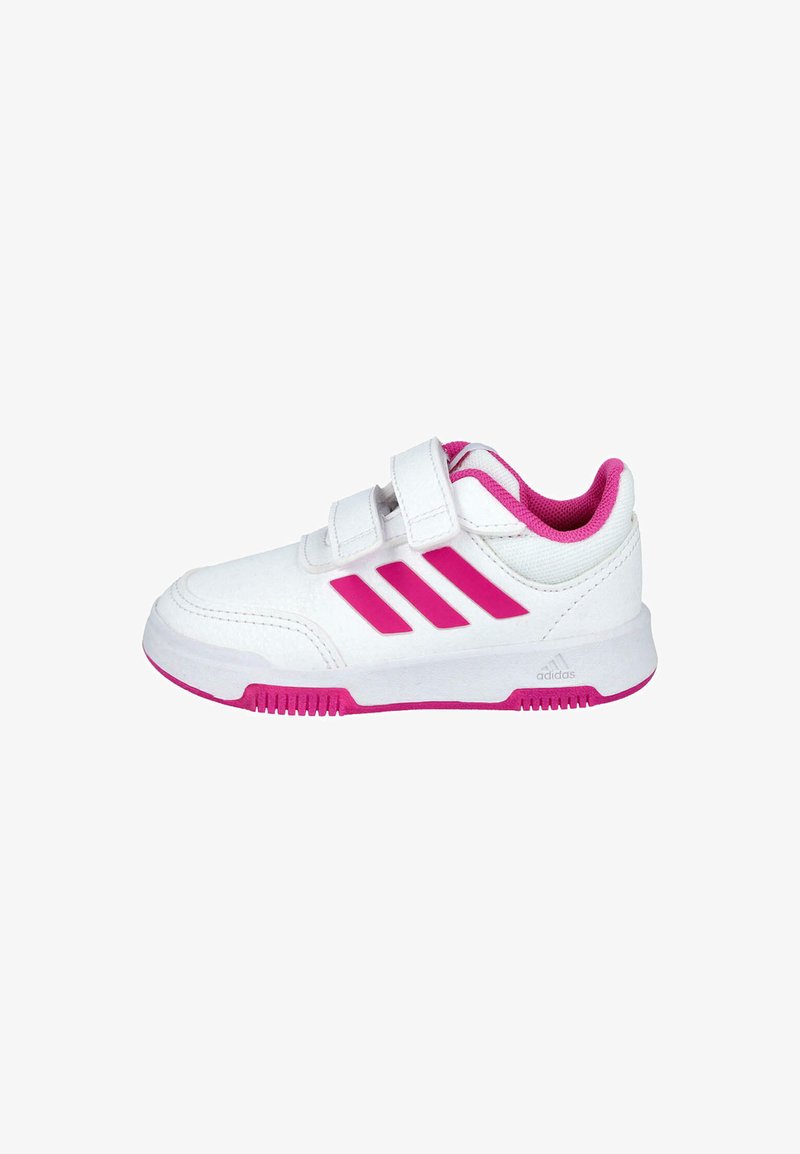 Zapatilla deportiva blanca con acentos rosas y tres rayas, que cuenta con un cierre de tiras de velcro, suela de goma y un interior acolchado.