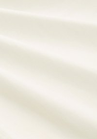 Cremefarbenes Gewebe mit einer glatten, leicht strukturierten Oberfläche, die sanfte Falten und Drapierungen im Bild zeigt.