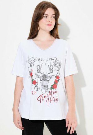 T-shirt blanc à manches courtes avec un col en dentelle, mettant en avant un design imprimé de cerf entouré de fleurs et le texte "Trachten Herz" en rouge.