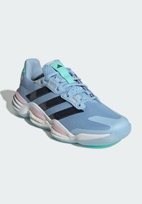 Zapatilla deportiva azul clara con parte superior de malla, rayas negras, acentos en rosa, cuello acolchado y suela texturizada para tracción.