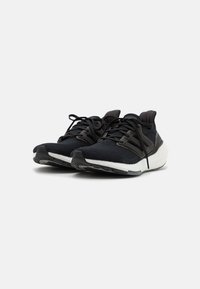Zapatos deportivos negros con una parte superior texturizada, una mediasuela blanca en contraste, cordones finos y un acolchado en el collar para mayor comodidad.