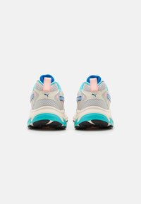 Tylny widok szarych butów sportowych z turkusowymi akcentami, jasnoróżowymi zakładkami na piętach i niebieskim wnętrzem. Siatkowa cholewka z warstwowym wzorem zapewniającym wentylację.