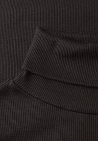 Ciemny materiał w prążki z złożonym kołnierzem, o gładkiej fakturze i dopasowanym kroju. Kolor to głęboka czerń, podkreślająca wzór dzianiny.