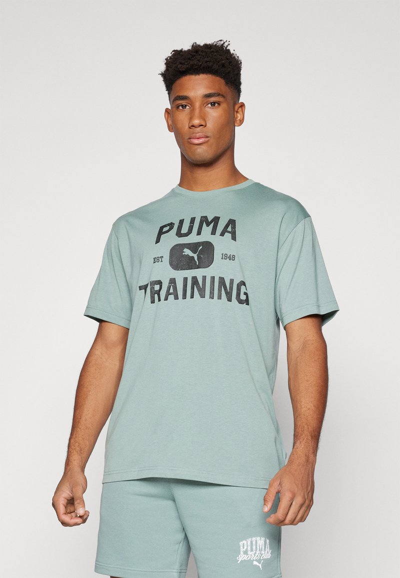 Tricou din bumbac de culoare verde mentă, cu imprimeu negru "PUMA TRAINING" și logo, cu mâneci scurte și croială lejeră.