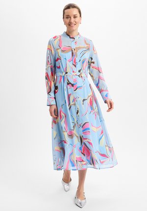 Langärmliges Hemdblusenkleid in Hellblau mit mehrfarbigen abstrakten Mustern, verfügt über eine taillierte Taille mit Gürtel und einen fließenden Rock mit leichtem Glanz.