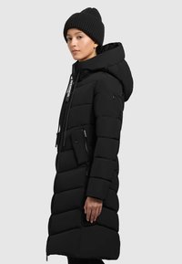 Cappotto imbottito nero con cappuccio, dotato di chiusura a zip, tasche laterali e una cintura con logo a contrasto. Tessuto morbido, design fino al ginocchio.