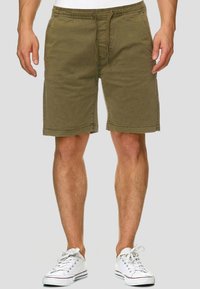 Olivgrüne Baumwollshorts mit elastischem Bund, Kordelzugverschluss, zwei Seitentaschen und geradem Schnitt, der oberhalb des Knies endet.