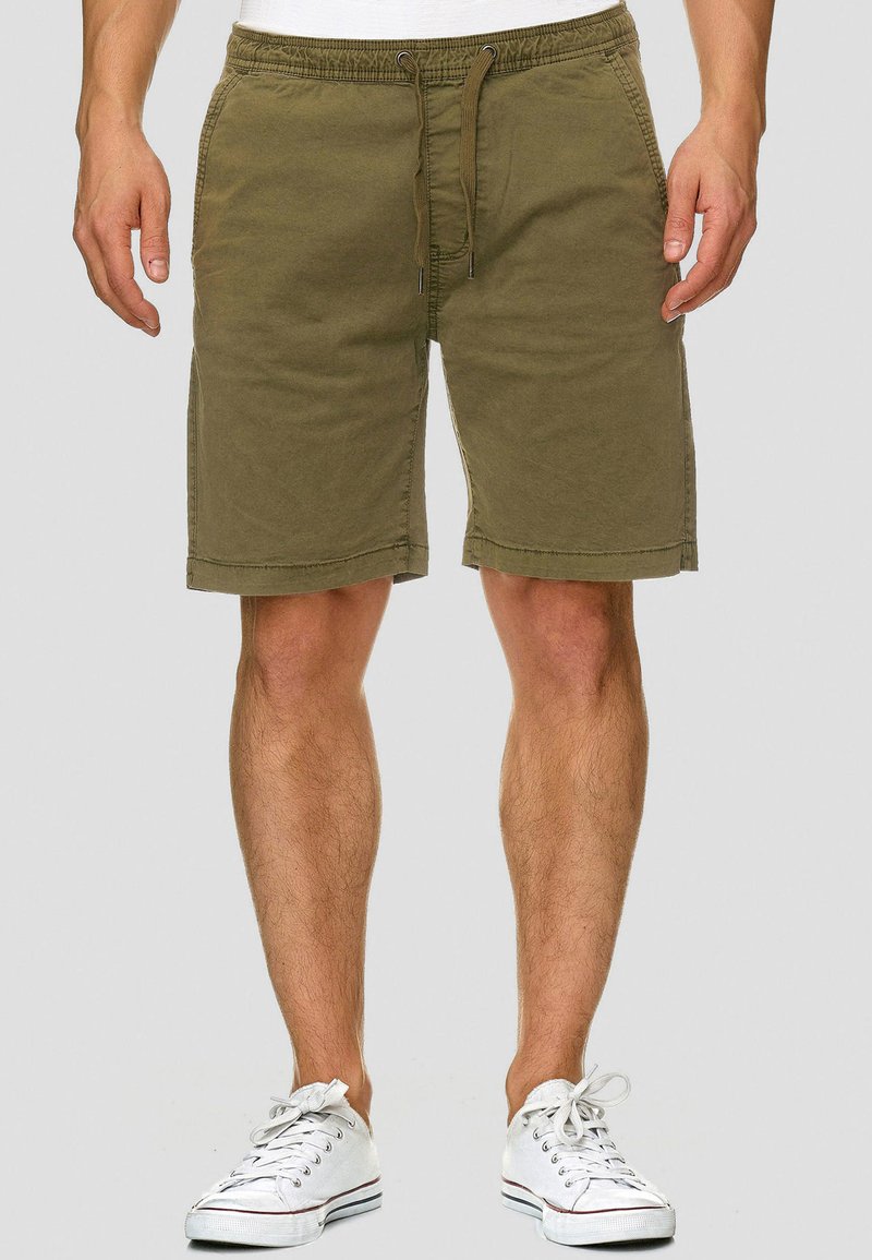 Olivgrüne Baumwollshorts mit elastischem Bund, Kordelzugverschluss, zwei Seitentaschen und geradem Schnitt, der oberhalb des Knies endet.