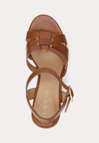 Hnedé kožené sandále s viacerými popruhmi, otvorenou špičkou a prackou okolo členku. Hladká textura so semi-matným finišom a polstrovanou stielkou.