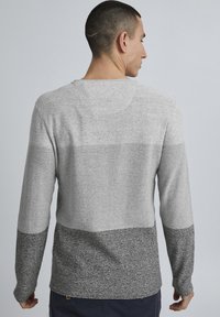 Pulover lung gri cu mâneci lungi, realizat dintr-un tricot texturat, având un design gradient: gri deschis în partea superioară, gri mediu în centru și gri închis la tiv.
