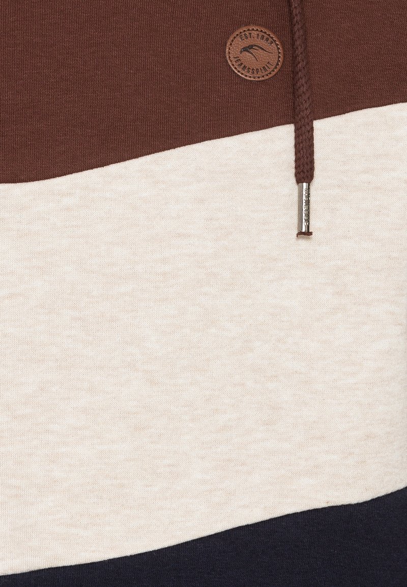 Brun, krämfärgad och marinblå färgblockerad sweatshirt med en strukturerad yta, utrustad med en rund logotypapplikation och en flätad dragsko.