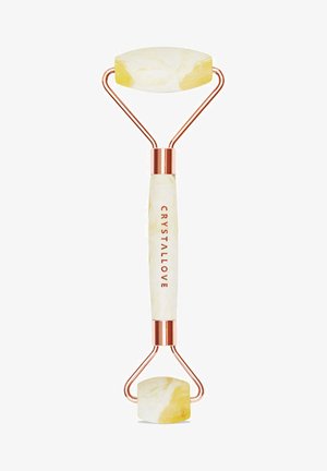 Jade roller met twee gemarmerde gele stenen hoofden, roségouden hardware en een witte handgreep met de tekst "CRYSTALLOVE."