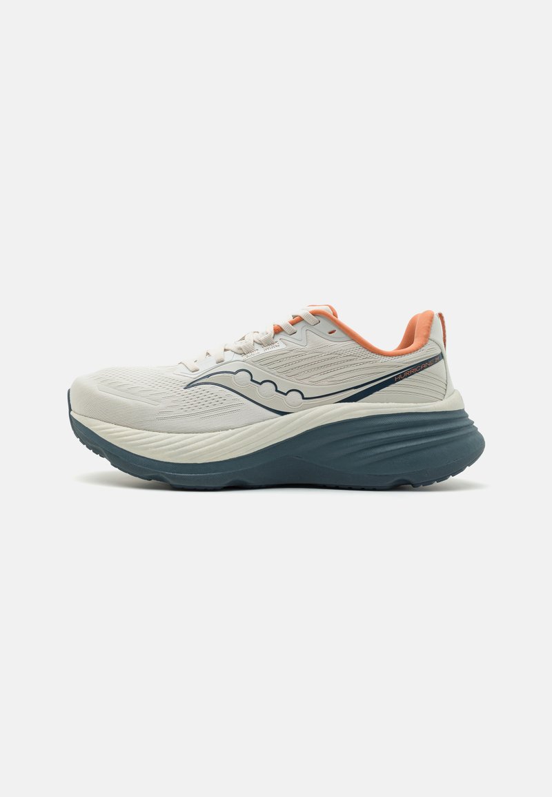 Chaussure de course avec une tige en maille blanche, des accents corail et une semelle extérieure en caoutchouc bleu foncé. Présente des éléments de design ondulés et une semelle intermédiaire rembourrée.