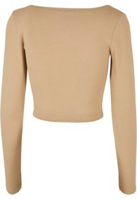 Langärmliges, kurzes Oberteil aus einem weichen, hellbraunen Stoff. Verfügt über einen runden Ausschnitt und glatt anliegende Ärmel. Einfaches und schmuckloses Design.