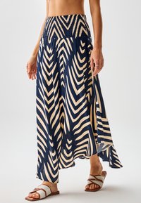 Falda larga en azul marino y crema con un patrón de zigzag en forma de chevron. Cintura elástica fruncida y aberturas laterales; tela ligera que ofrece una apariencia fluida.