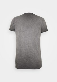 Grå bomulds t-shirt med korte ærmer og rund halsudskæring. Har en subtil tekstur og en let mørkere kant ved kanterne.