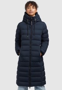 Mörkblå pufferjacka med en lång, vadderad design, som har hög hals, justerbar dragsko-huva och sidofickor.